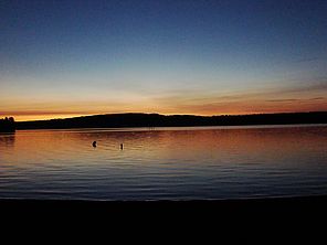 Lake Champlain sunset. Oranges appear where light needs to pass through more of the atmosphere. Transition from white in center to dark blue at top of image shows an increase in Rayleigh scattering and a decrease in Mie scattering as altitude increases. P