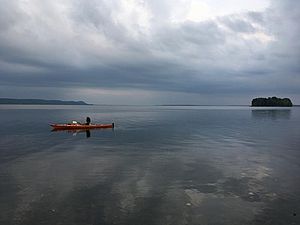 Photo of a kayaker on Lake Champlain on a cloudy day.