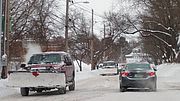 Photo of a snowplow on a snowy road. 